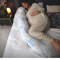 Pregnant woman relaxing in comfort on bed with full body xxl u shaped pregnancy pillow. Large pregnancy pillow helps pelvic girdle pain. Pregnancy pillow allows you to get sleep. Supports your bump. Sleeping in final trimester. Nice looking pregnancy pillow. Best pregnancy pillow UK. BellaMoon Pregnancy and Nursing Pillow